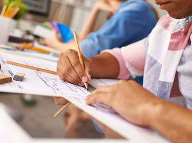 Close up of teen student sitting at a desk and writing on paper