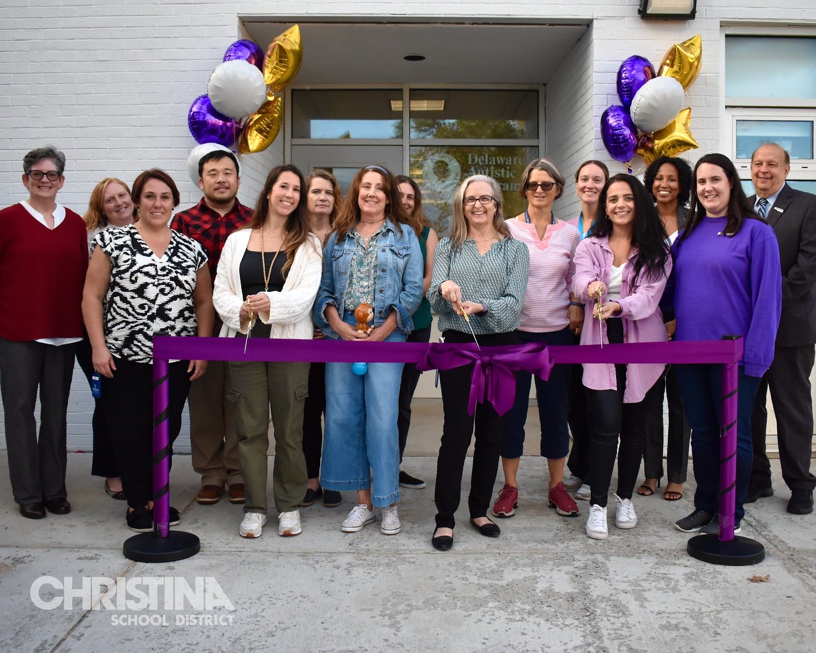 Photo of Brennen School staff, administration and board members at purple ribbon cutting