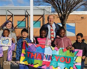 Oberle students with Superintendent and teacher with colorful banner that reads "Thank You"