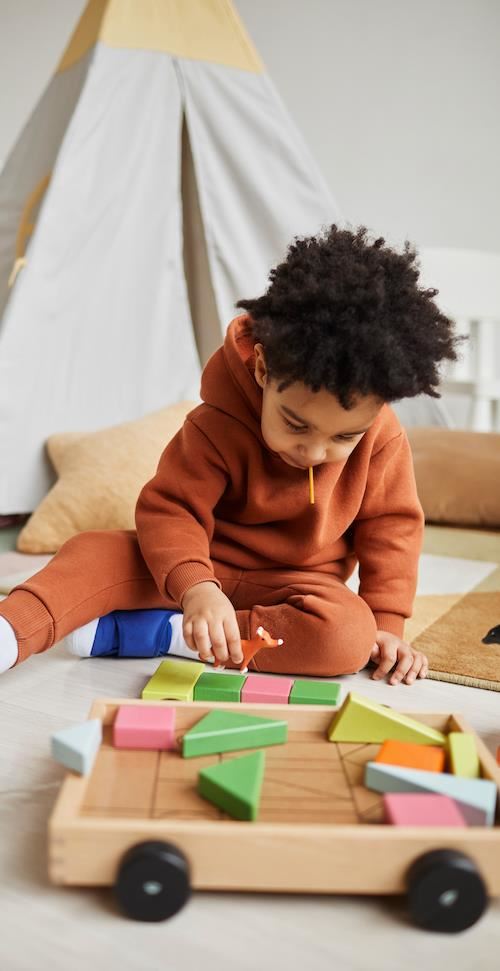 vertical-portrait-cute-african-american-toddler-playing-with-wooden-toys-cozy-kids-room